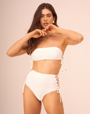 Top de biquíni off-white com design faixa e entrelaçados laterais, visto de frente.
