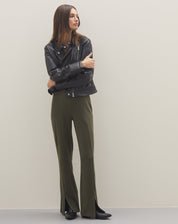 Imagem de uma pessoa usando jaqueta preta e calça verde, complementando o look com botas pretas estilo western.