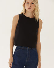 Modelo vestindo top cropped preto com calça jeans de cintura alta.