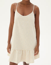 Vestido curto bege com alças finas, detalhe de bordado floral e barra em babado.