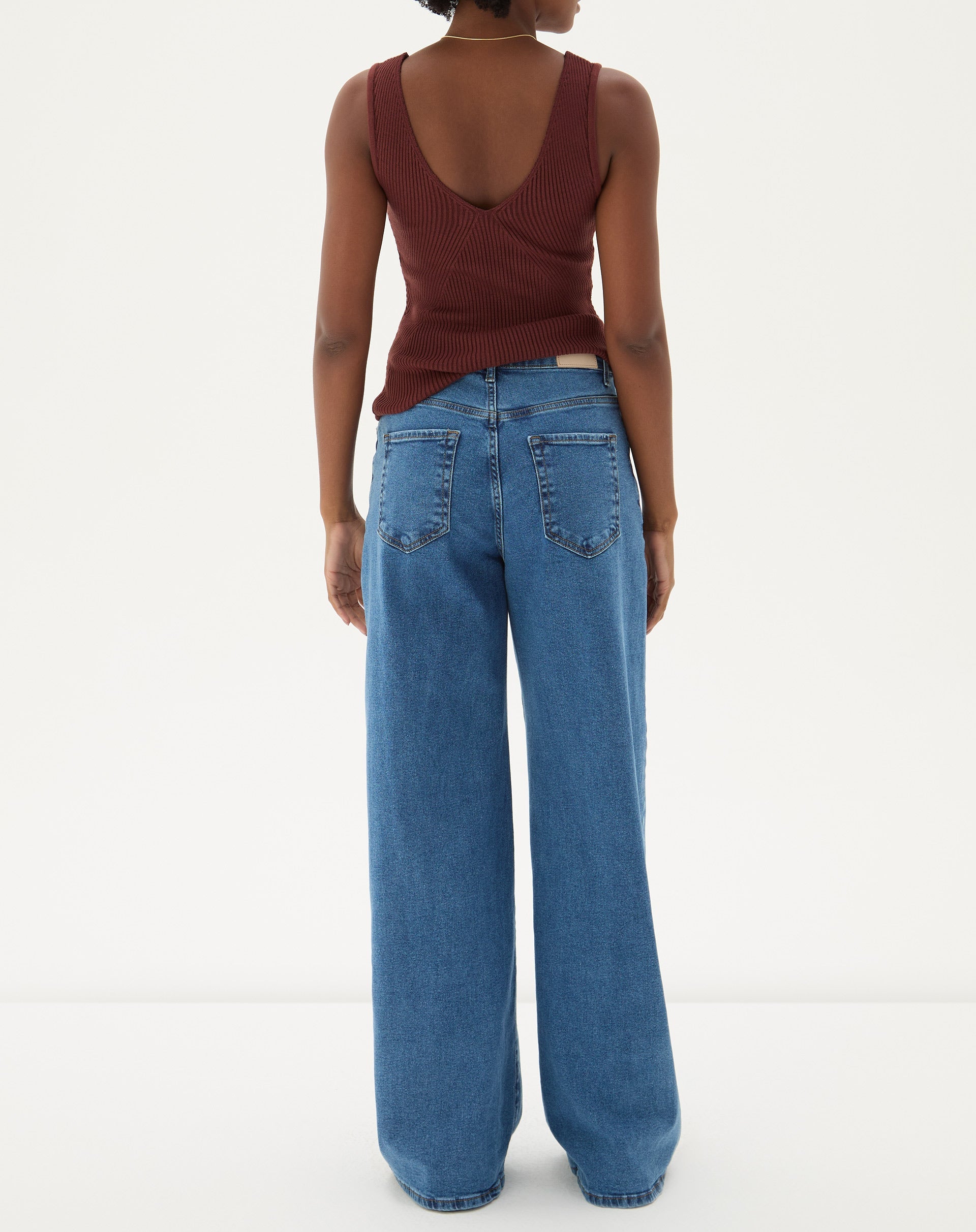 Vista traseira da calça jeans wide leg azul médio mostrando os bolsos traseiros.
