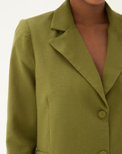 Detalhe da lapela e fechamento do blazer verde militar.