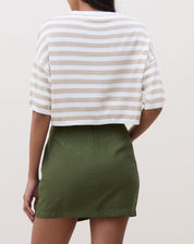 Modelo vestindo saia curta transpassada verde militar com blusa preta.