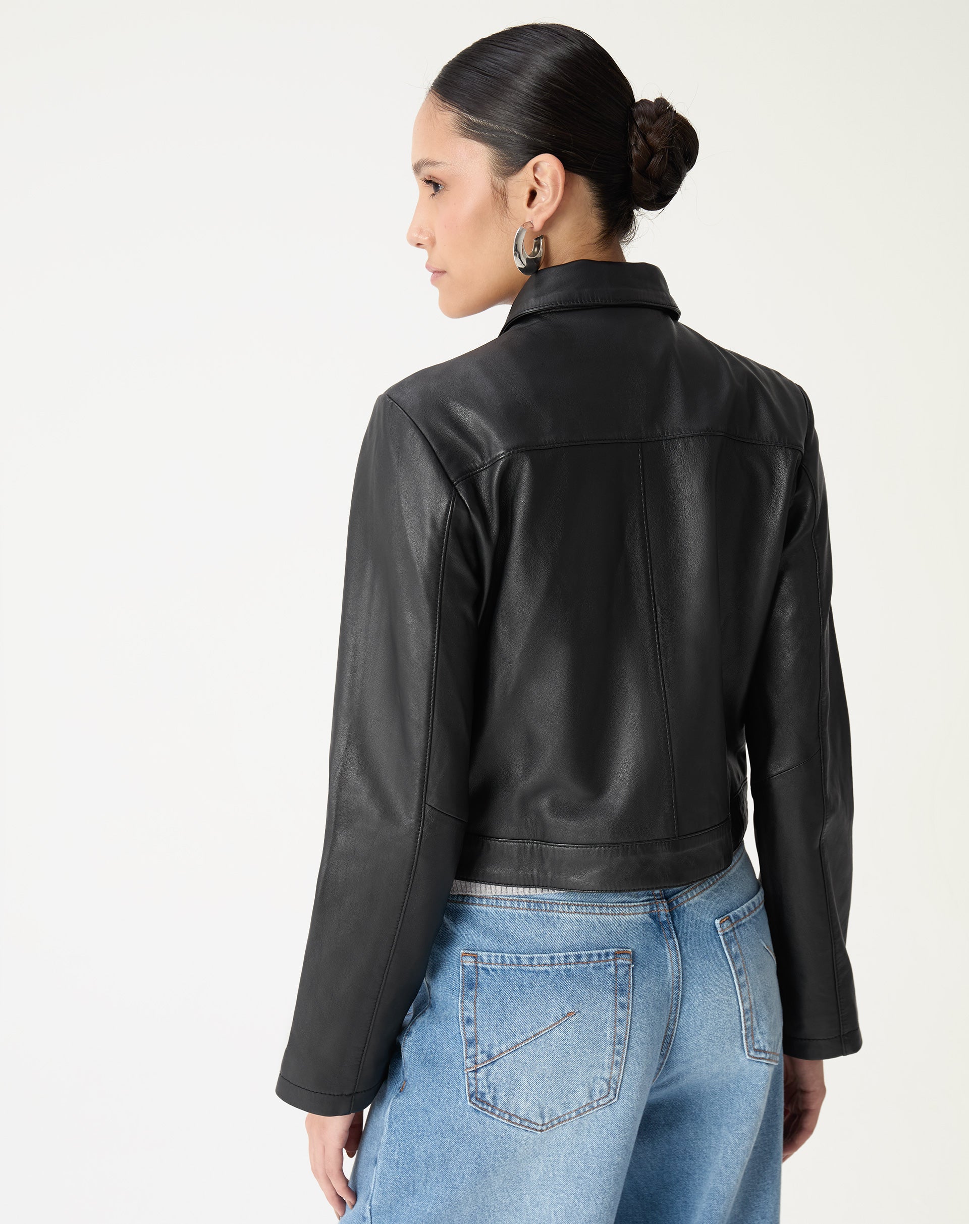 Costas da jaqueta de couro preta mostrando barra curta e corte estruturado na altura da cintura