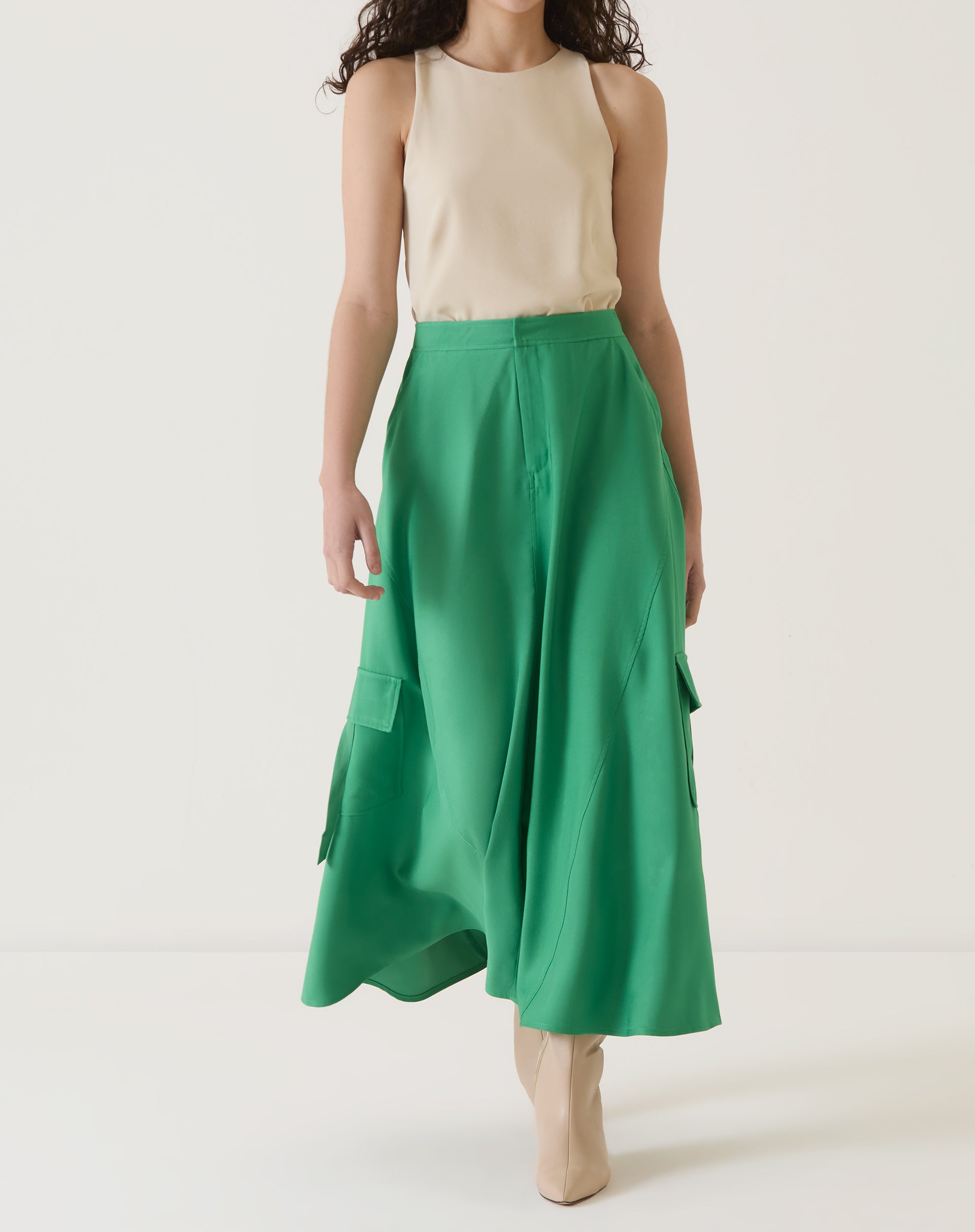 Modelo vestindo saia verde com bolsos cargo, vista frontal.