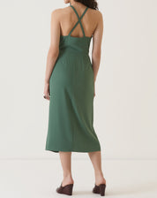 Vista traseira do vestido verde com alças cruzadas e comprimento midi.