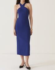 Vestido azul com alças transpassadas, comprimento midi, visto de lado.