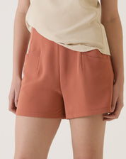 Close-up do shorts de alfaiataria vinho mostrando os bolsos.