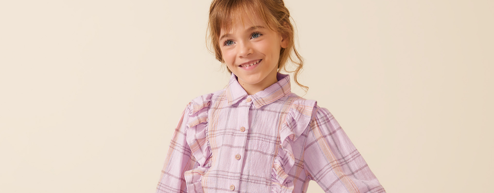 menina vestindo look infantil com blusa xadrez de manga comprida