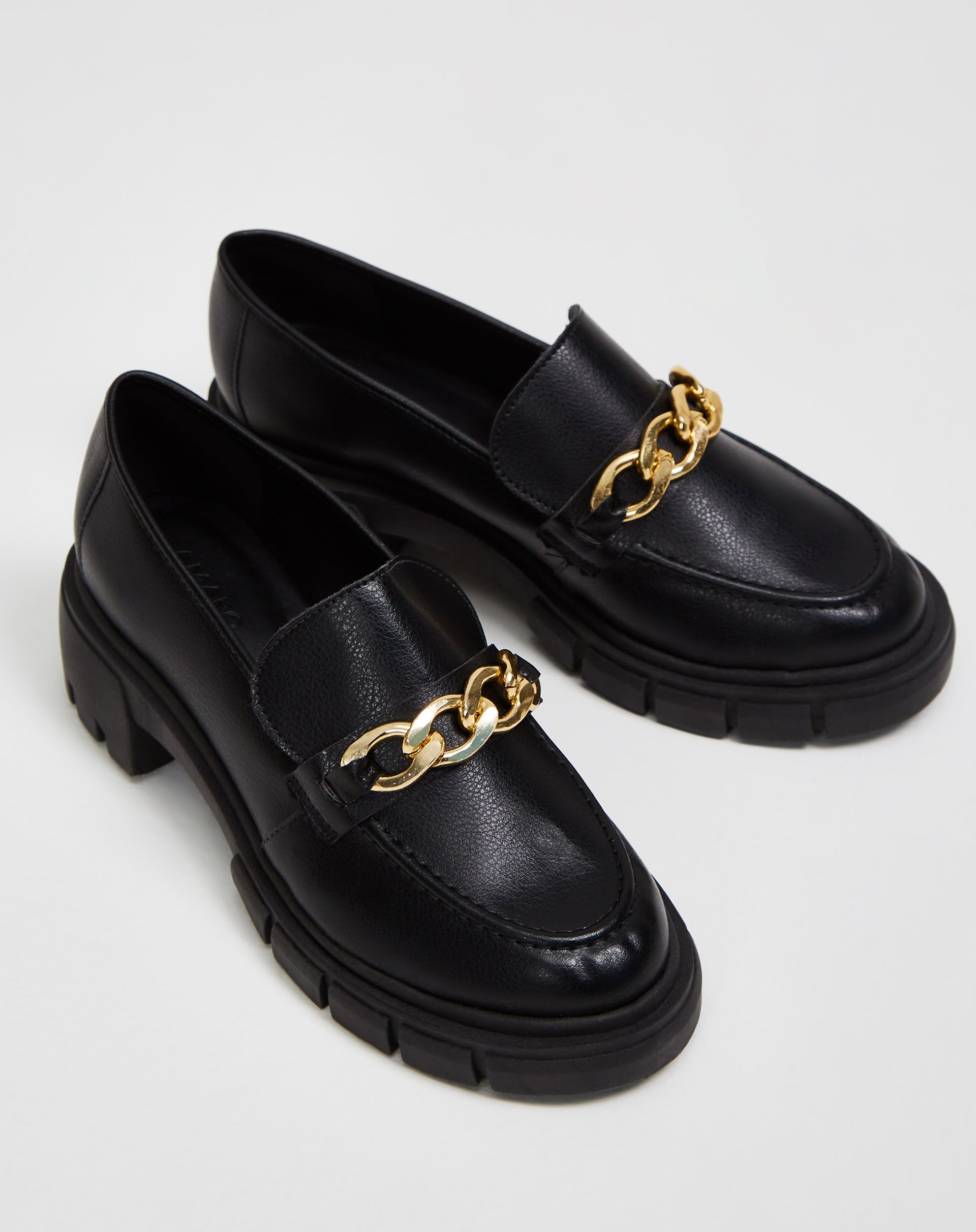 Mocassim Chunky preto com corrente de metal, vista superior mostrando detalhes do cabedal.