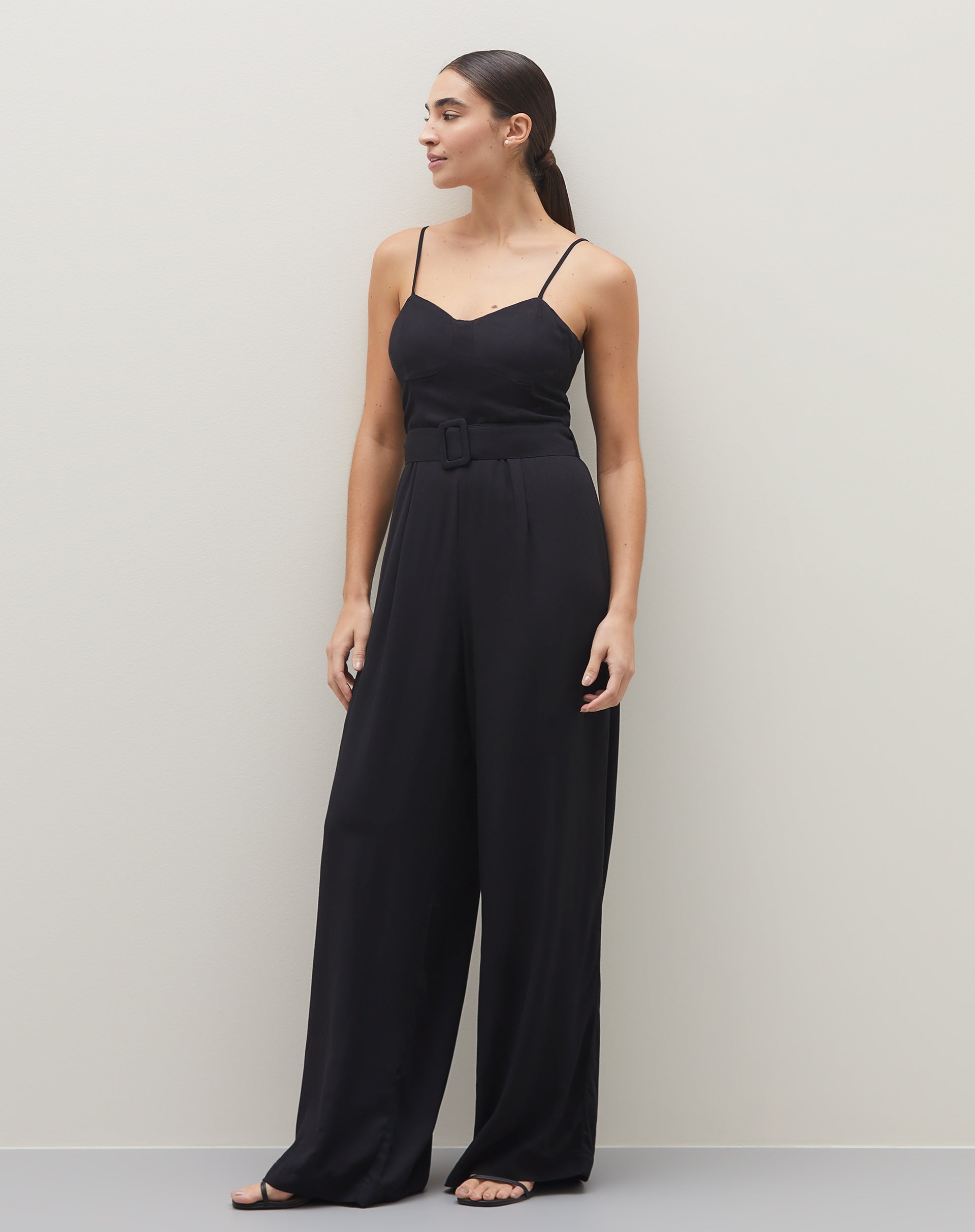Macacão preto de alcinha com faixa, visto de frente, destacando o design elegante.