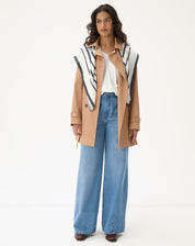 Camiseta de viscose com decote em V, combinada com calça jeans e casaco.