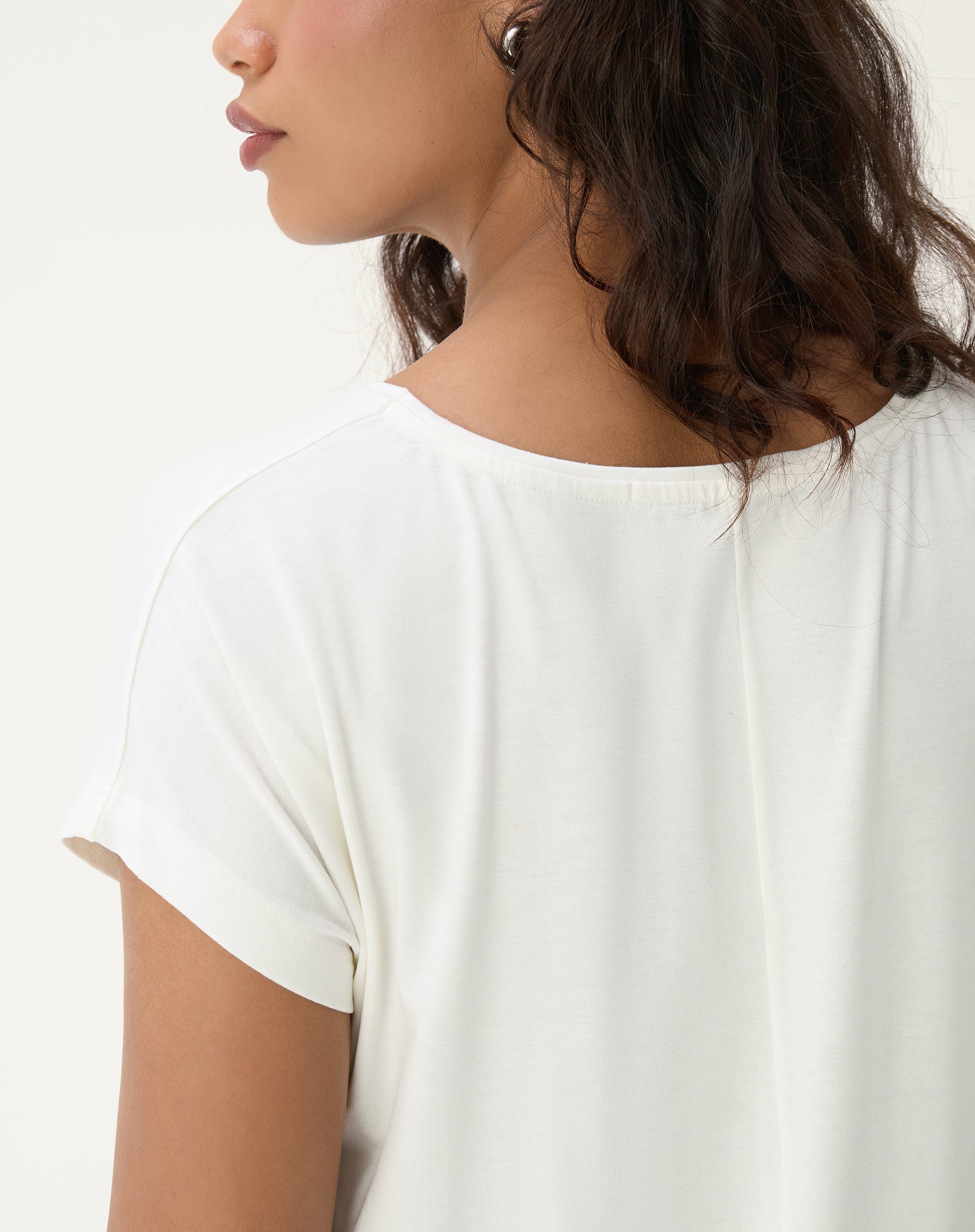 Detalhe lateral da camiseta de viscose com decote em V.