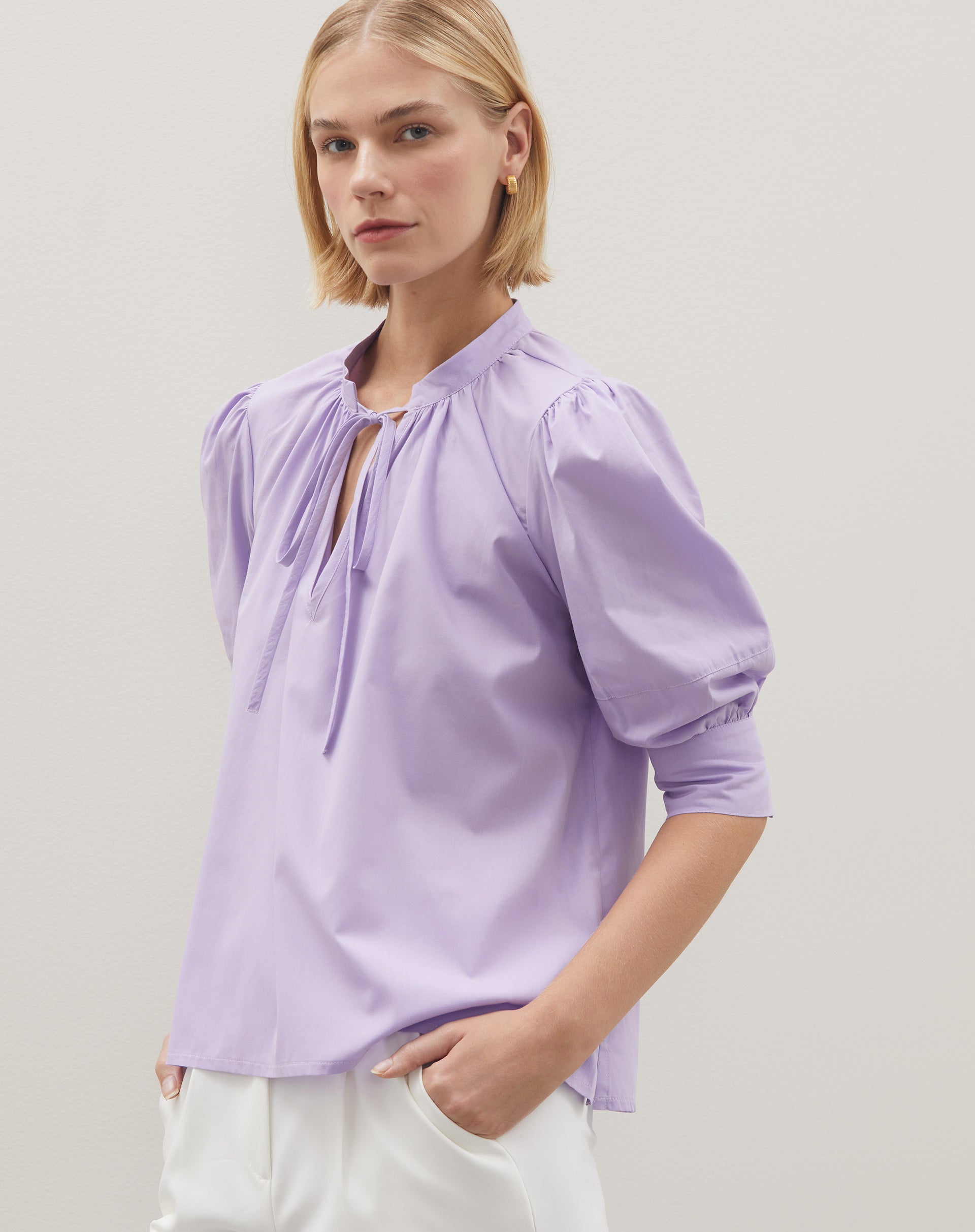 Blusa lilás com mangas bufantes e decote em V profundo, vista frontal.