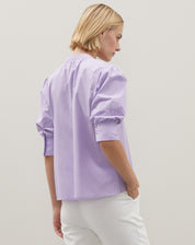 Vista traseira da blusa lilás com mangas bufantes.