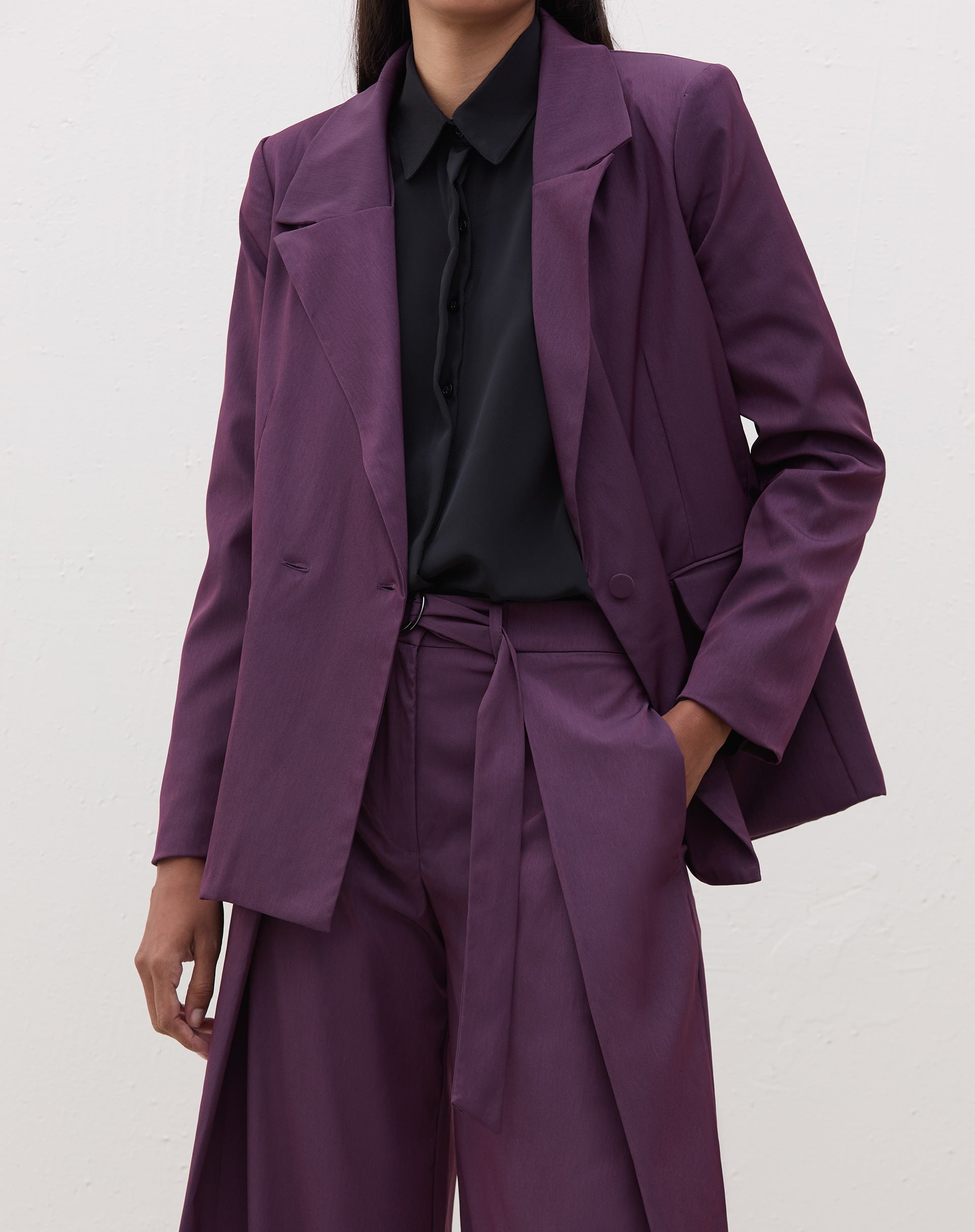 Blazer roxo com transpasse em alfaiataria, visto de frente.