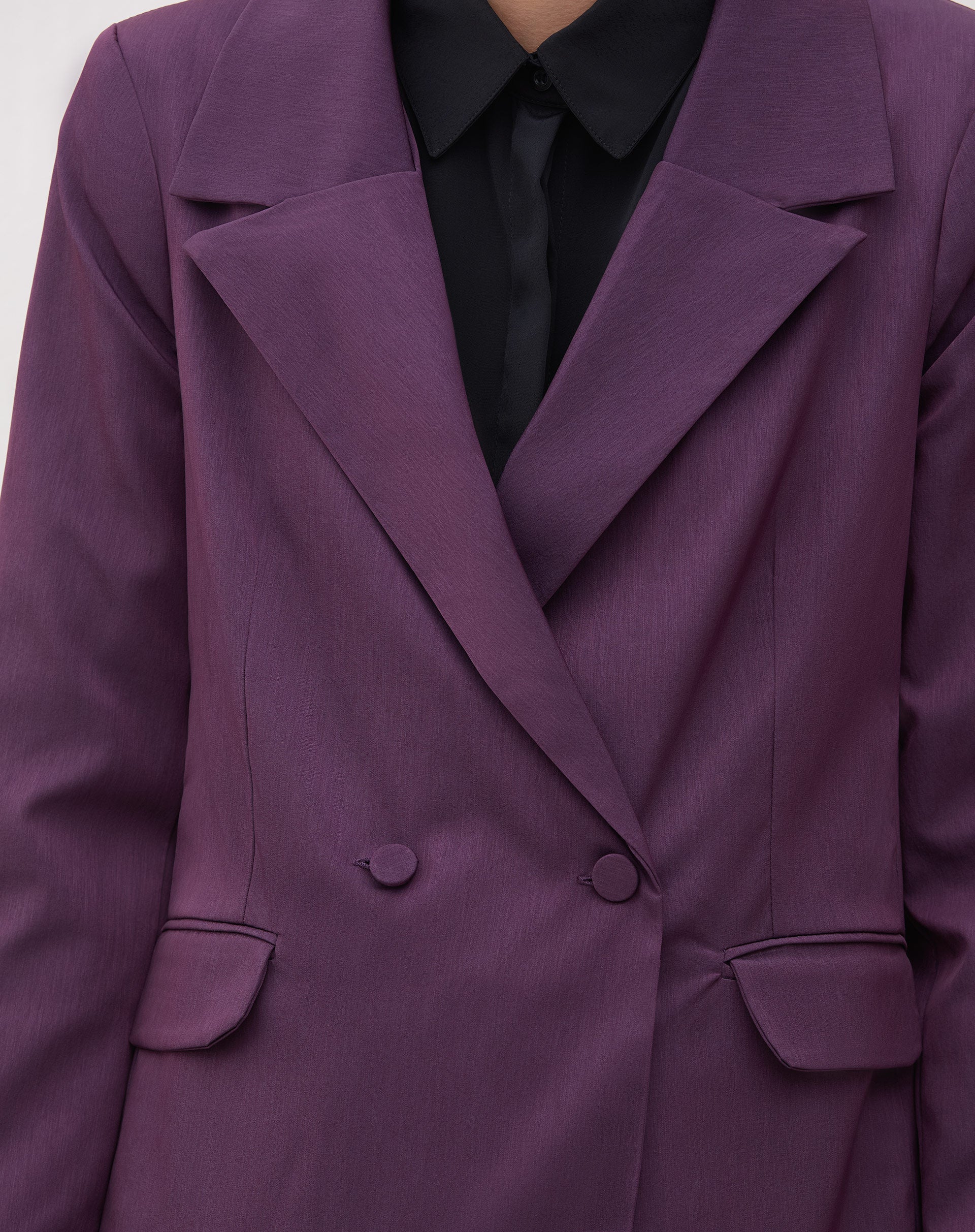 Close-up do blazer roxo mostrando os bolsos com aba e botões.