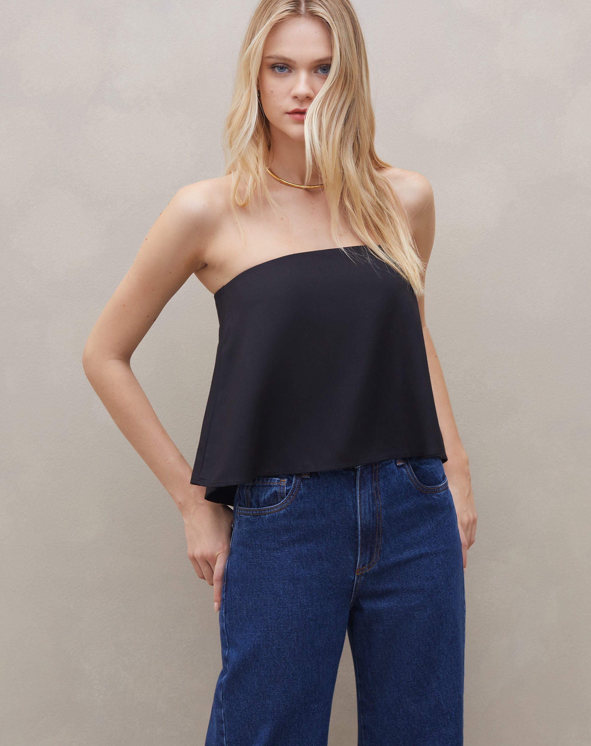 Close-up da blusa sem alça de crepe preta, destacando o tecido e o design minimalista.