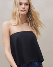 Modelo usando blusa sem alça de crepe preta, vista lateral para destacar o estilo.