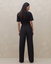 Detalhe do cós limpo e fechamento com botão da calça wide leg preta.