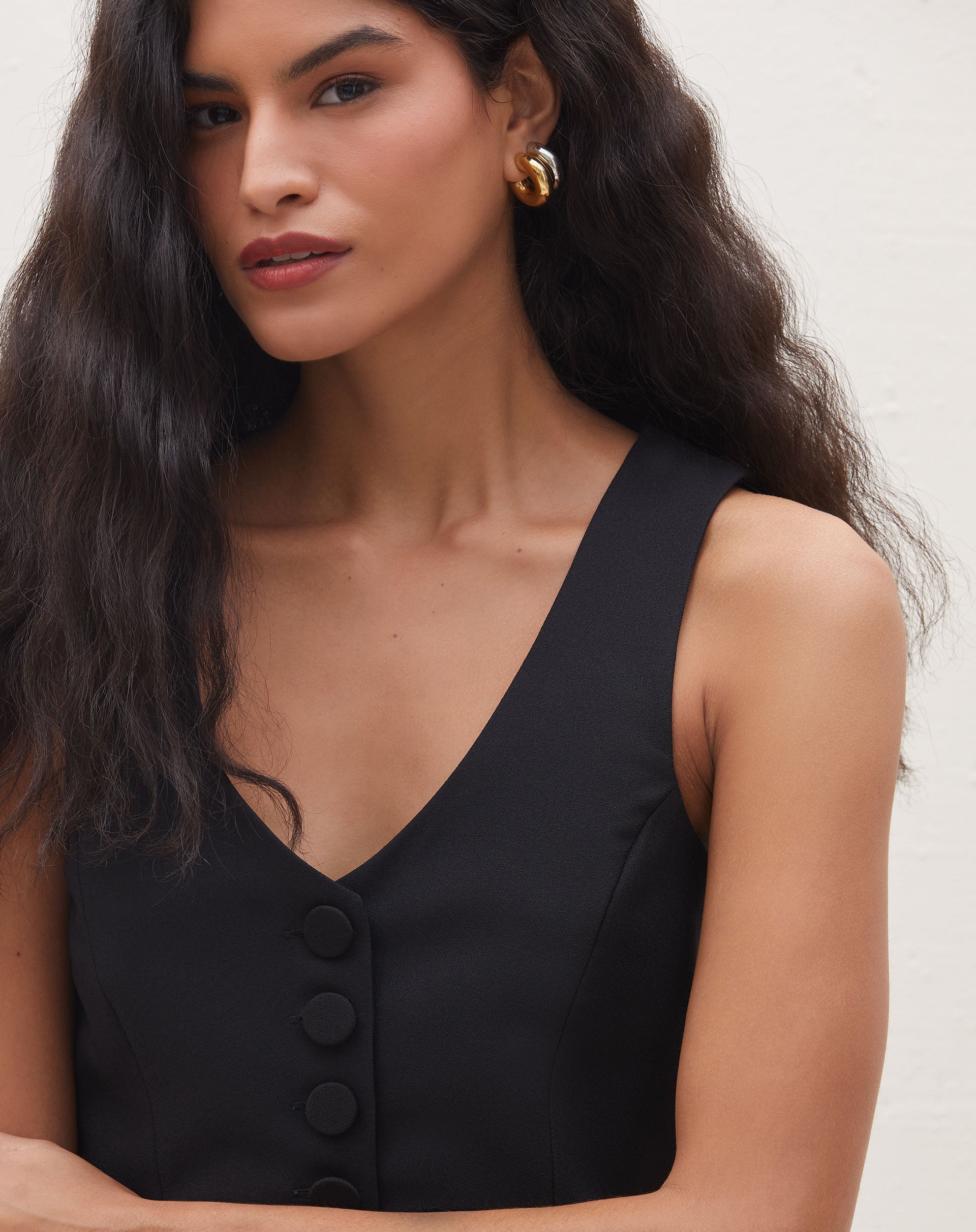 Close-up do colete preto de alfaiataria com decote em V.