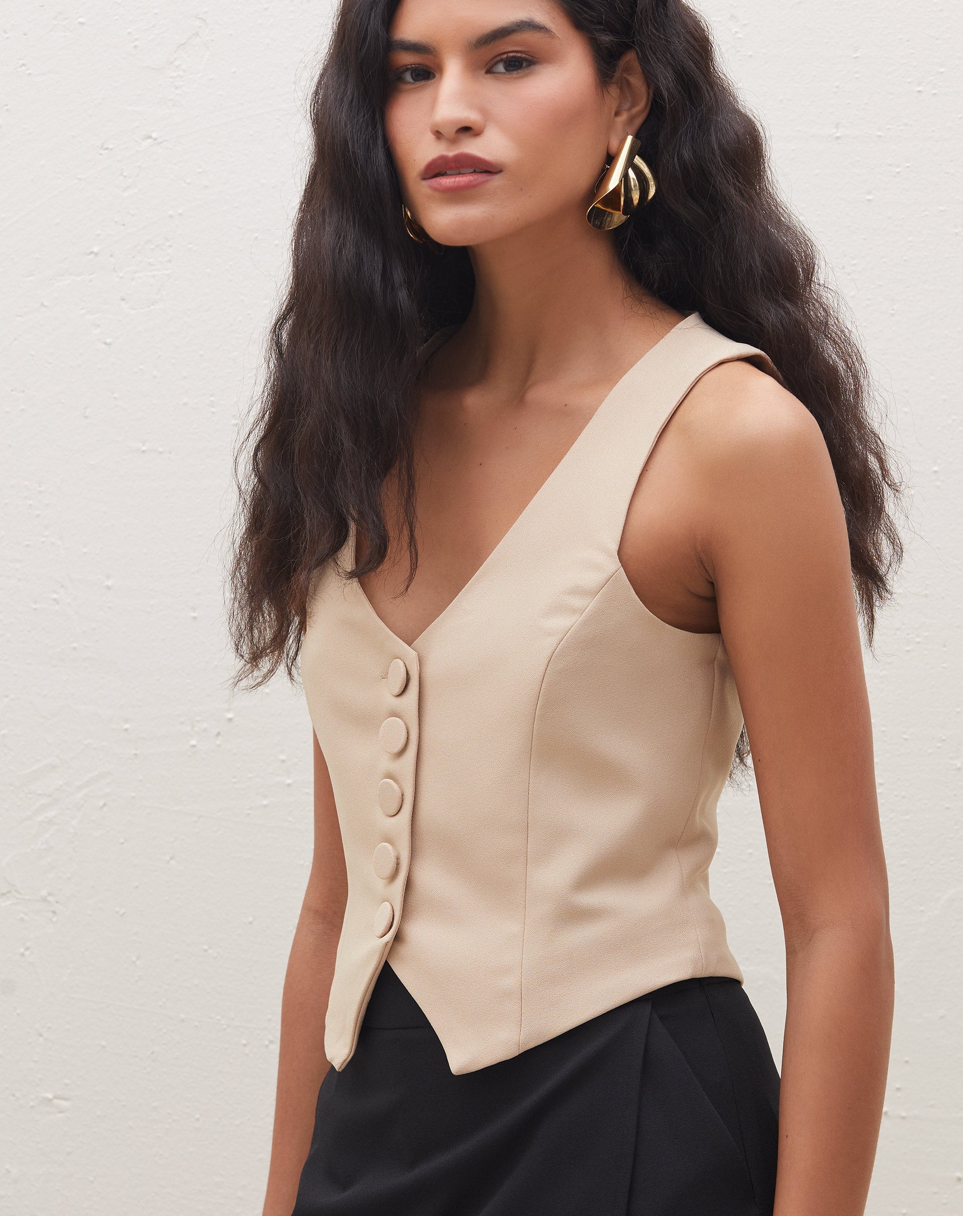 Imagem traseira do colete de alfaiataria bege, destacando o design sem mangas.