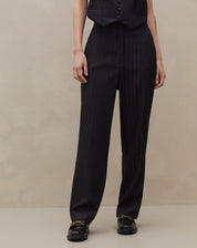 Vista frontal completa da calça preta cropped com risca de giz.