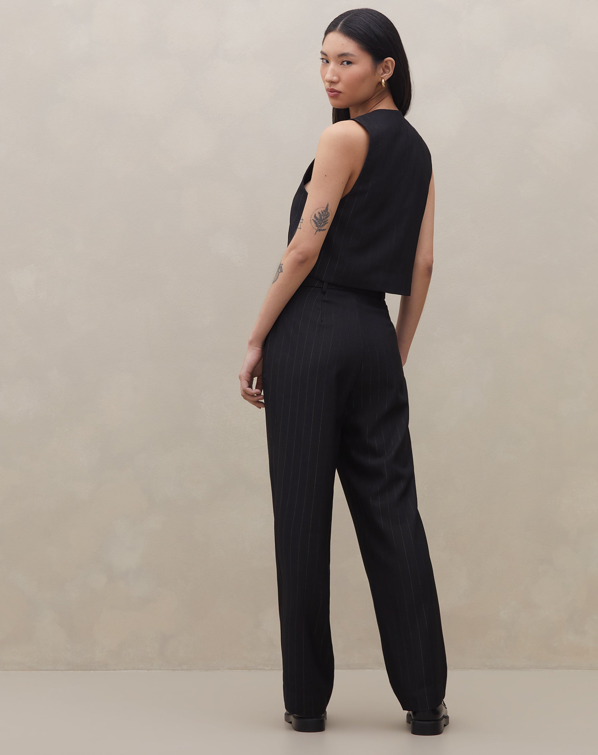 Vista traseira da calça preta cropped com risca de giz.