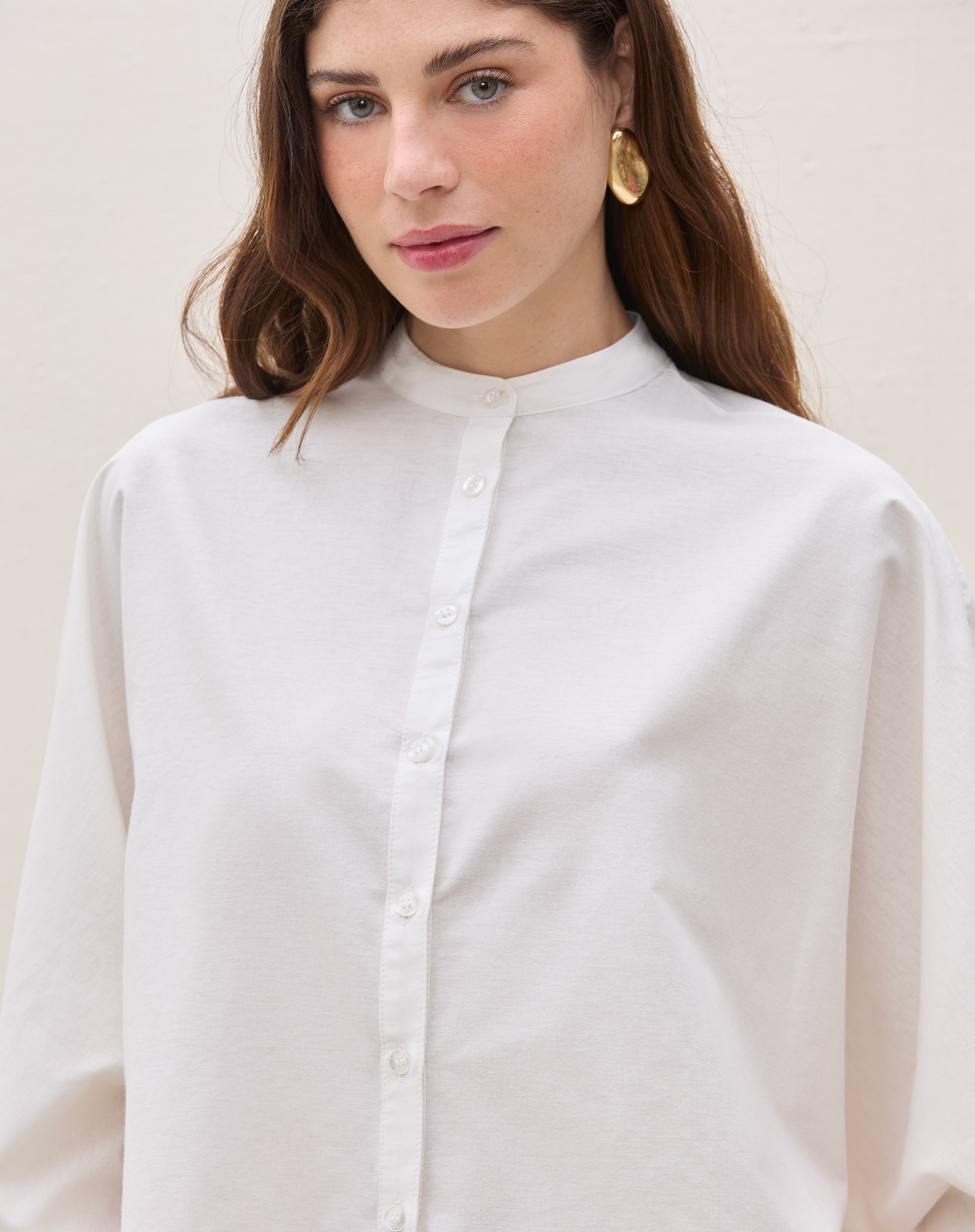 Detalhe da gola padre e fechamento com botões da camisa oversized.