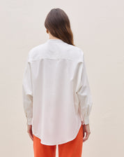 Vista traseira da camisa oversized com barra arredondada.