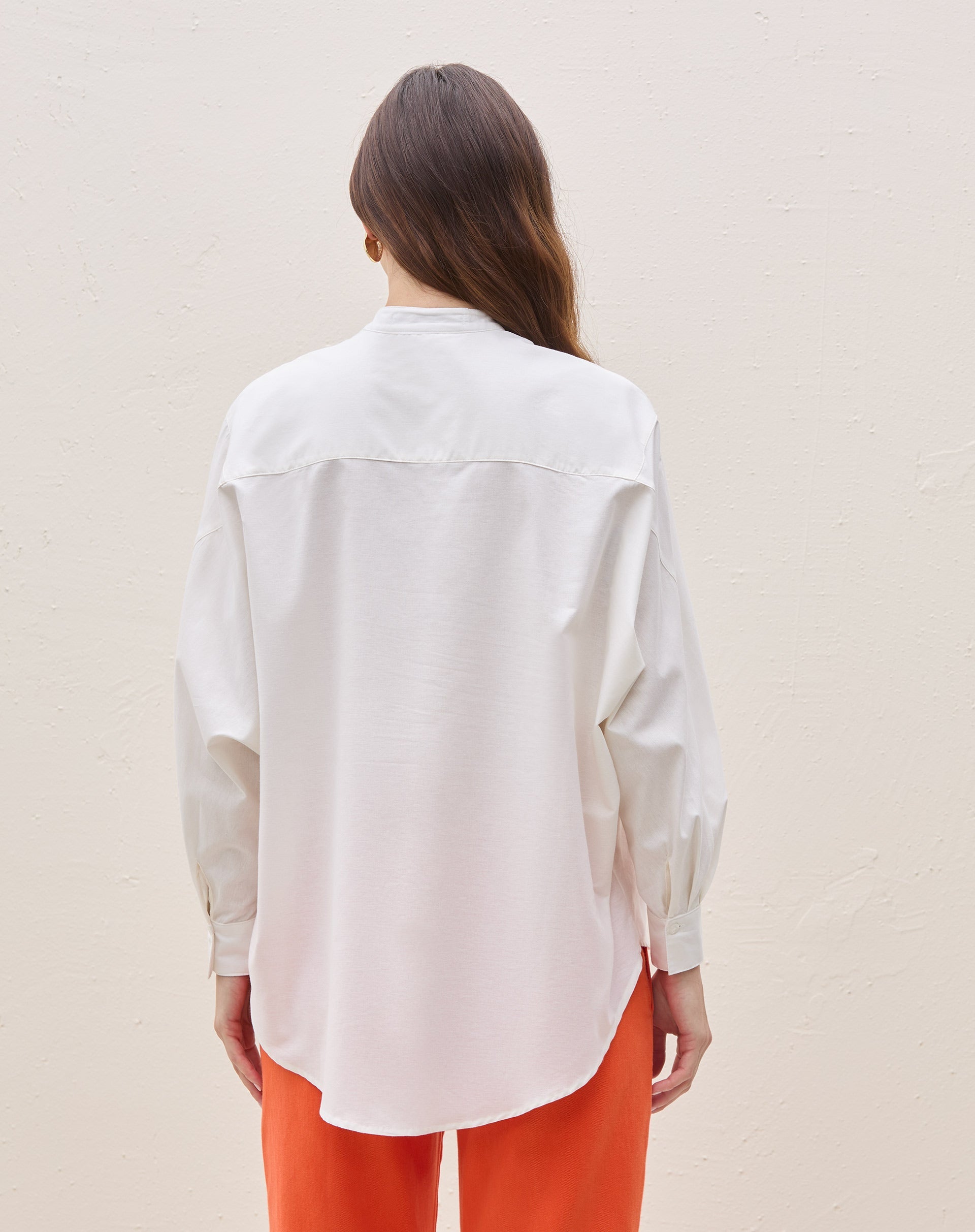 Vista traseira da camisa oversized com barra arredondada.