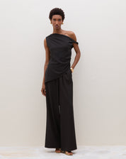 Blusa assimétrica de um ombro só em preto, vista completa com calça.