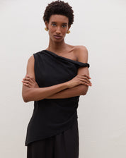 Blusa assimétrica de um ombro só em preto, detalhe do decote.