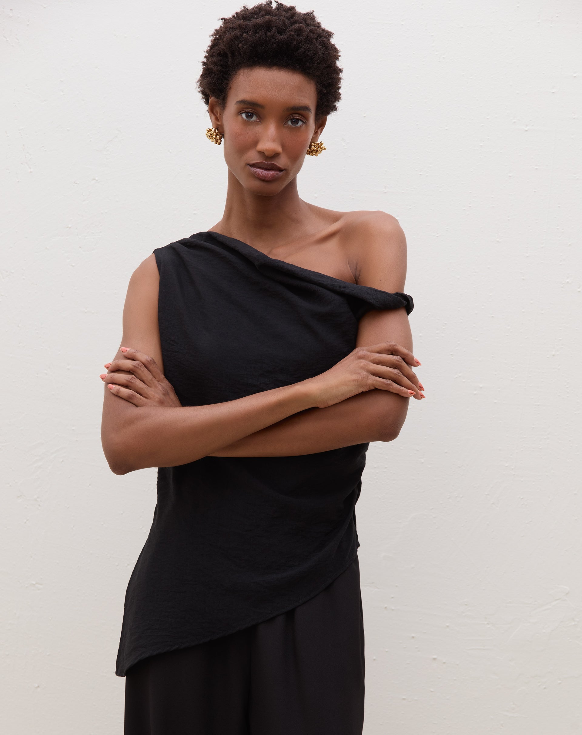 Blusa assimétrica de um ombro só em preto, detalhe do decote.