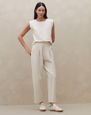 Modelo vestindo calça de cintura alta em malha texturizada, vista frontal.