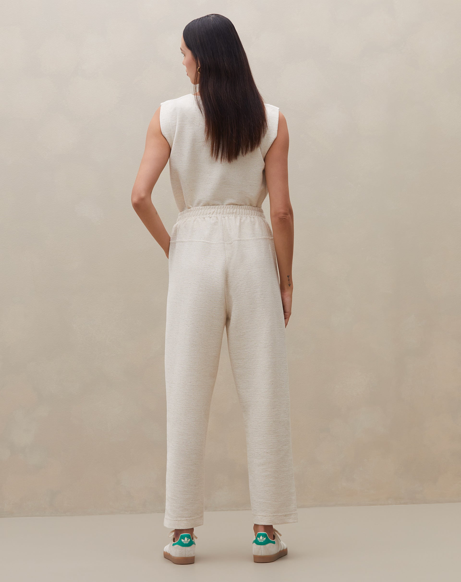 Vista traseira da calça de cintura alta em malha texturizada.