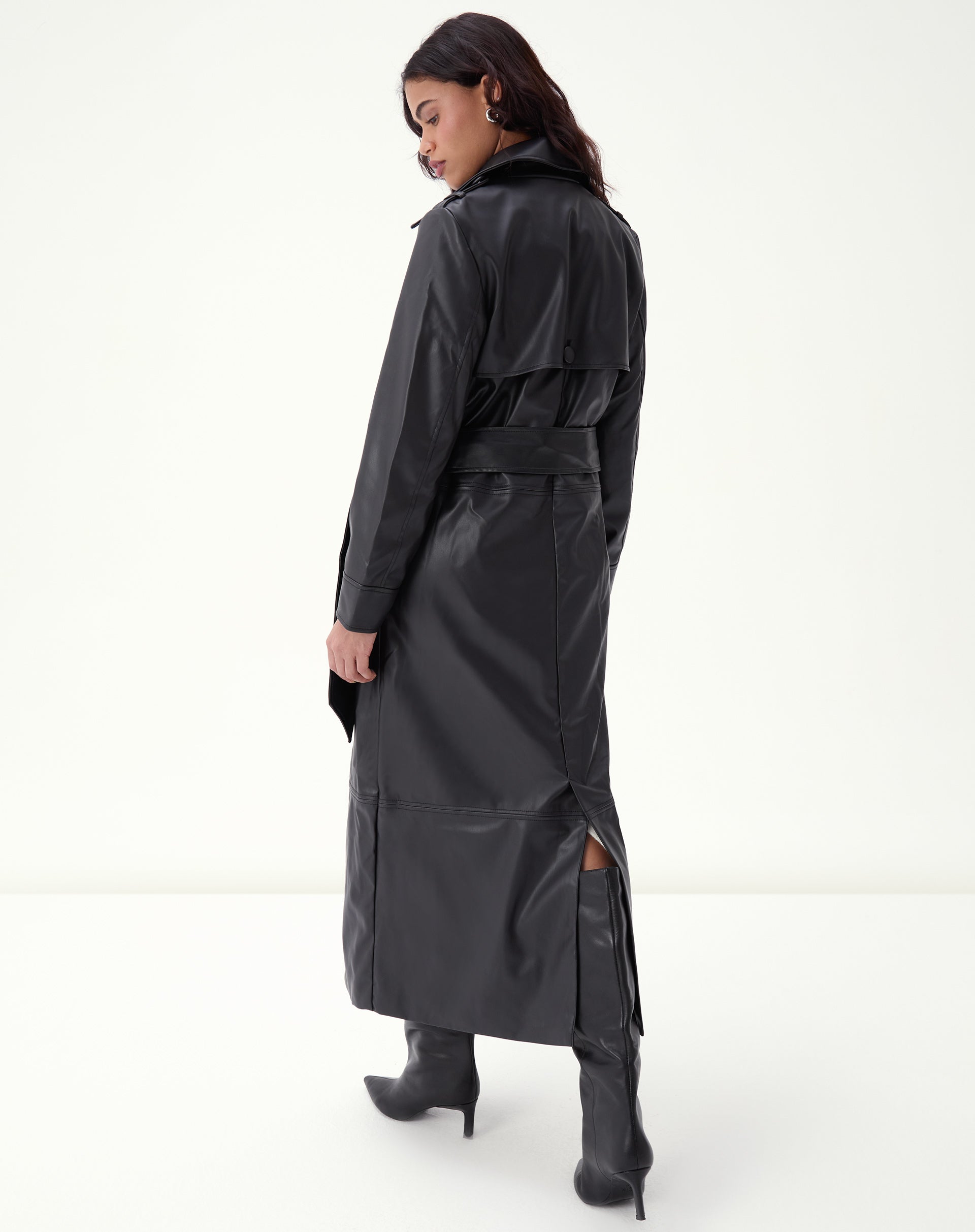 Close do torso do trench coat em PU preto exibindo pala frontal, bolso embutido e cinto amarrado com nó discreto.