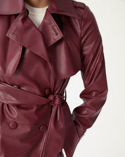 Detalhe da cintura com cinto de amarração e botões revestidos no trench coat vinho