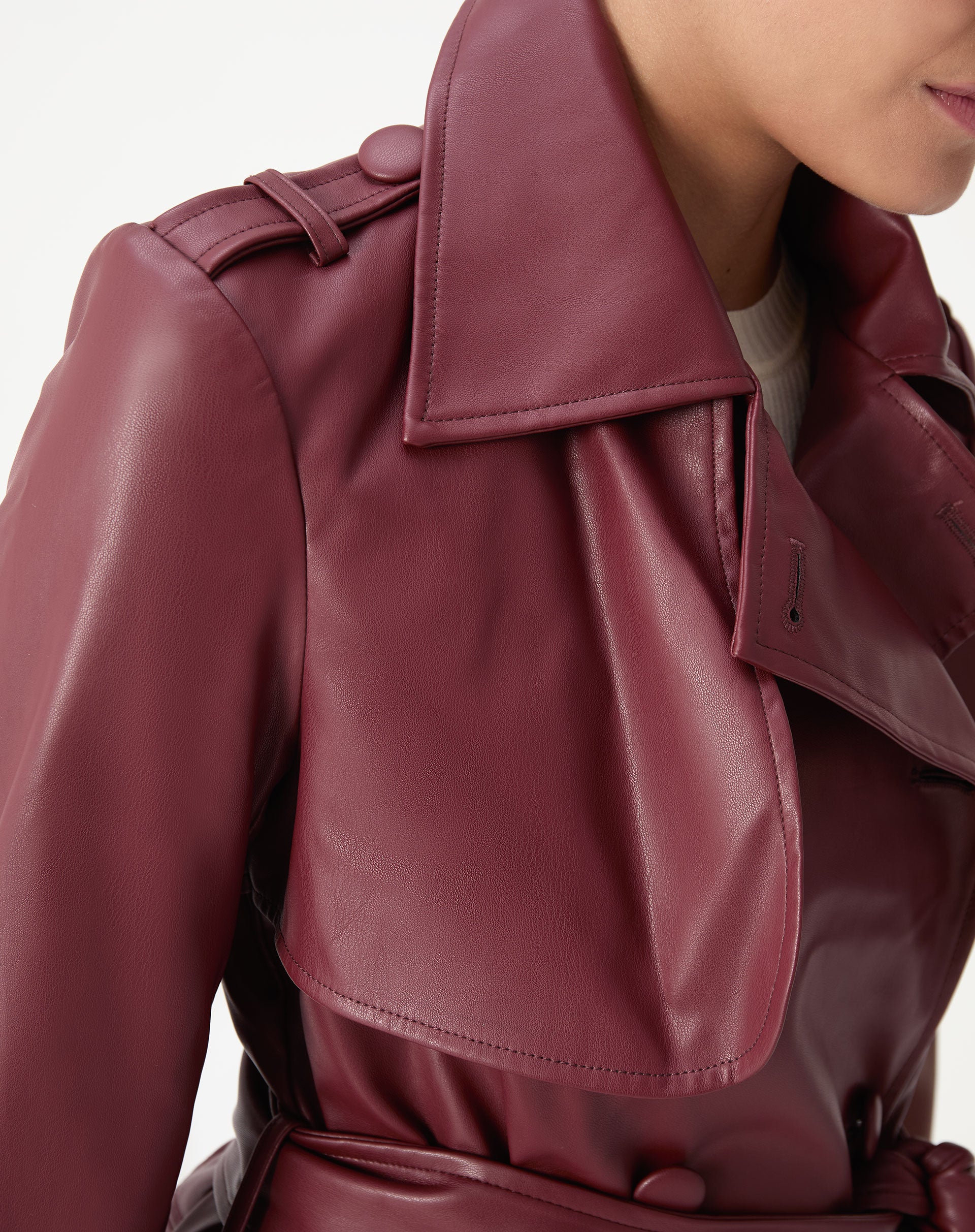Close na gola e pala do trench coat vinho em PU mostrando textura e acabamento