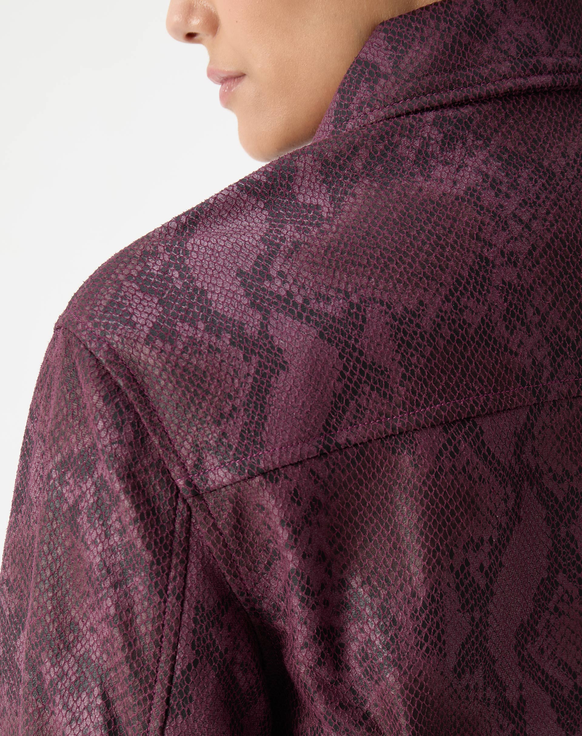 Visual completo com modelo usando jaqueta quadrada cobra em PU vinho e calça combinada, estilo urbano com botas pretas.