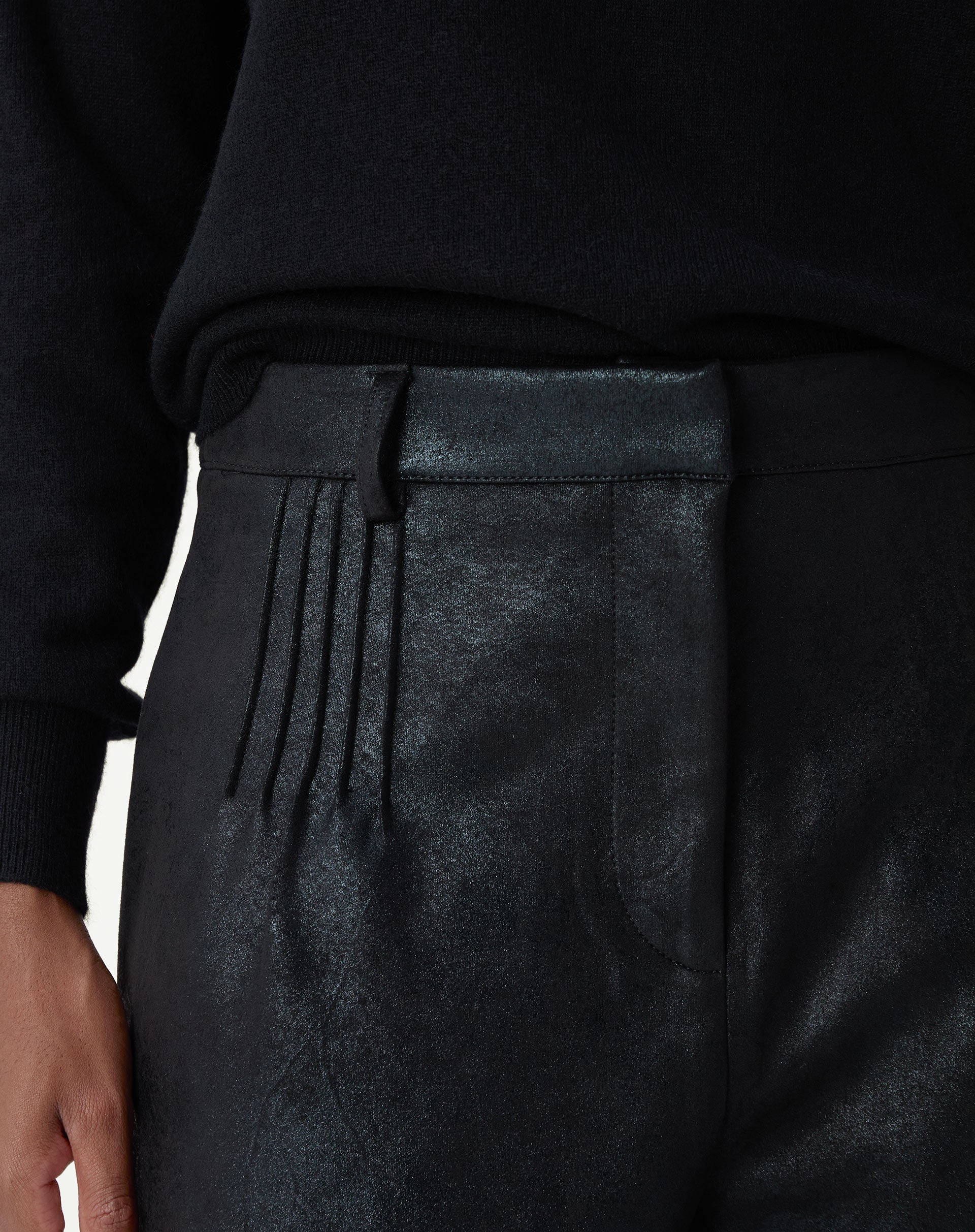 Flat lay do shorts metalizado preto com modelagem reta e bainha aplicada, destaque para o brilho discreto do tecido