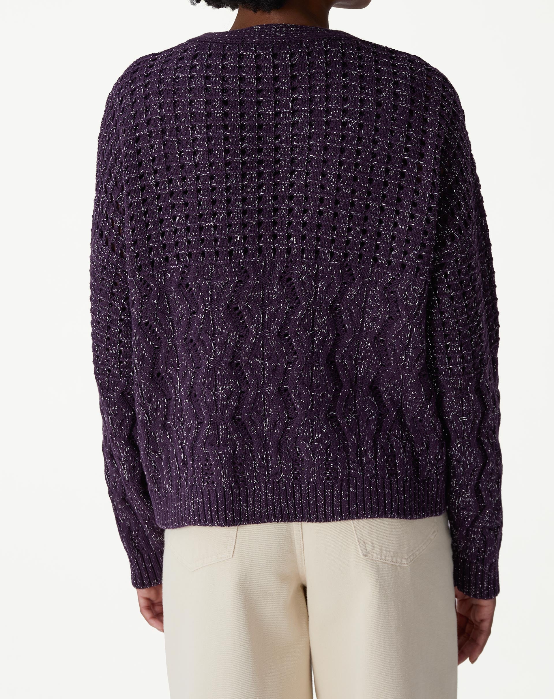 Look completo com modelo usando cardigan tricot roxo, calça wide-leg bege e sapato marrom, visual casual e sofisticado.