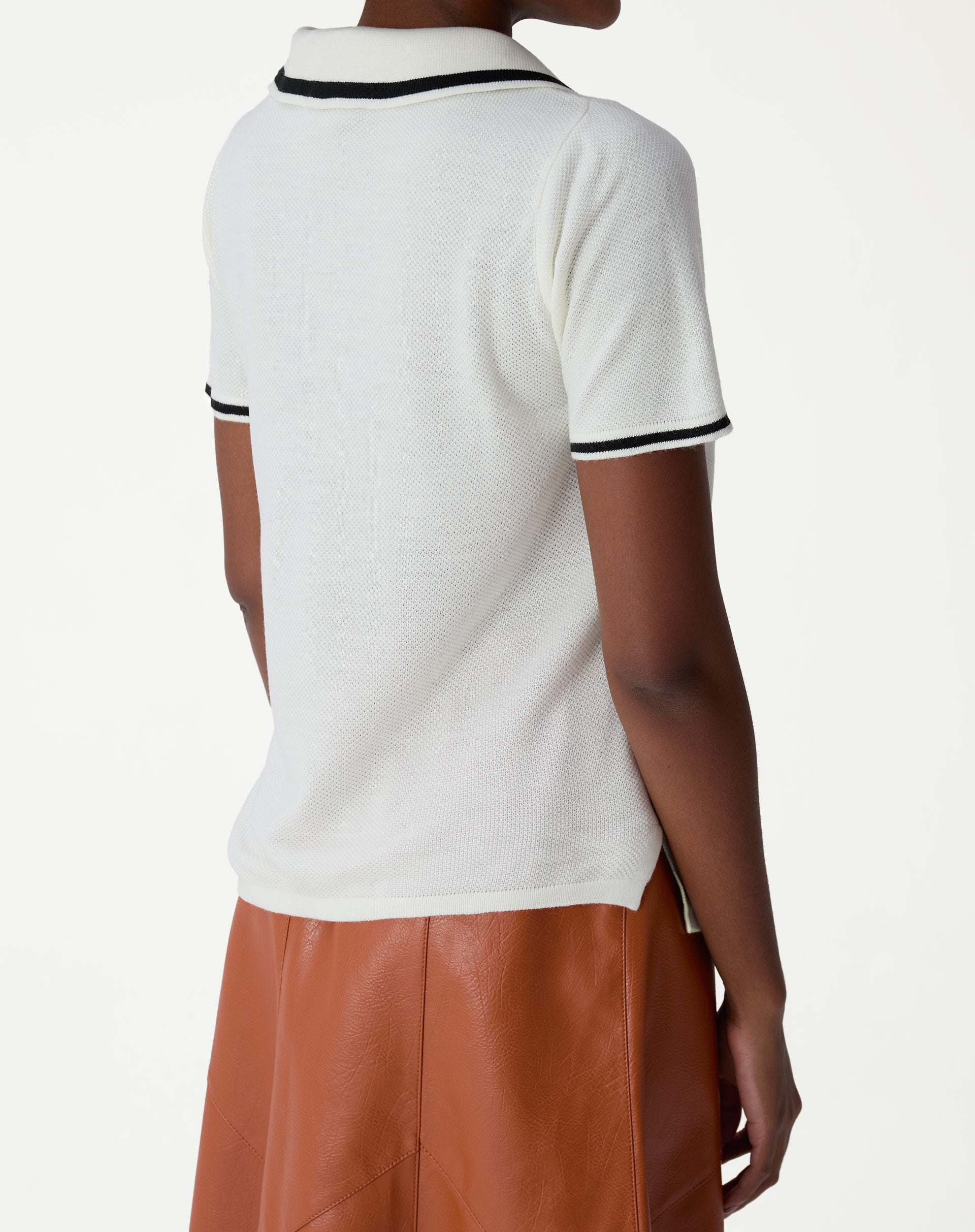 Close da gola polo off-white com listra preta e detalhe da textura em tricot, visual do acabamento da carcela