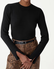 Fechamento no torso de modelo com suéter de tricô de gola redonda preto justo, destacando a textura canelada e o ajuste ao corpo.