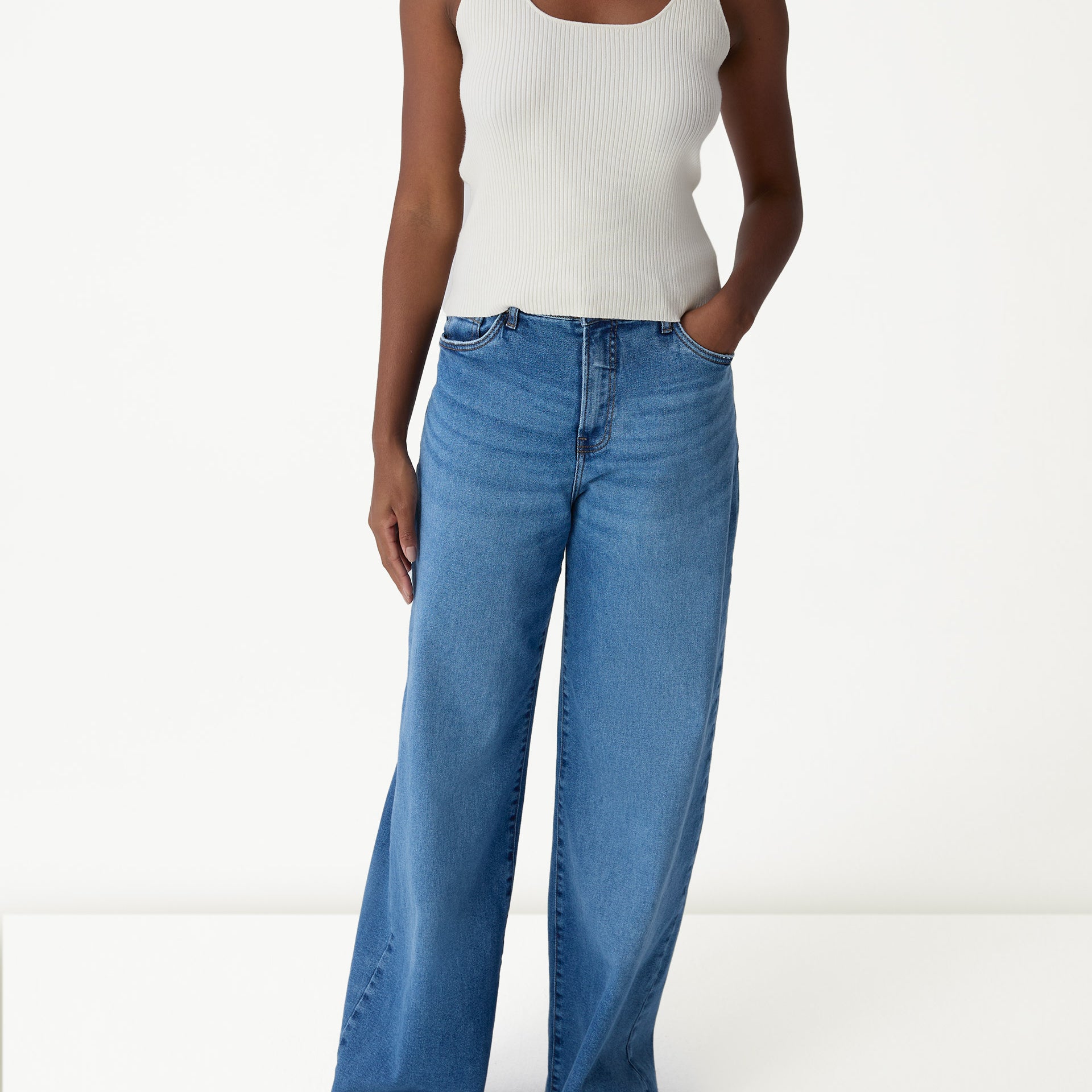 Look com regata tricot off-white usada sob camisa overshirt bege e calça jeans wide-leg - styling casual.