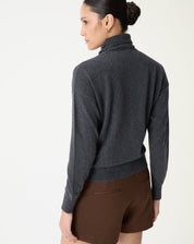 Look frontal com suéter de gola alta cinza mescla combinado com jaqueta marrom e shorts para um estilo casual chic.
