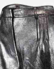 Close do cós do shorts metalizado prata com passantes, fechamento frontal e costura das pregas