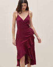 Vestido midi transpassado vinho mostrando amarração lateral na cintura e babado lateral — vista 3/4 lateral destacando o caimento.