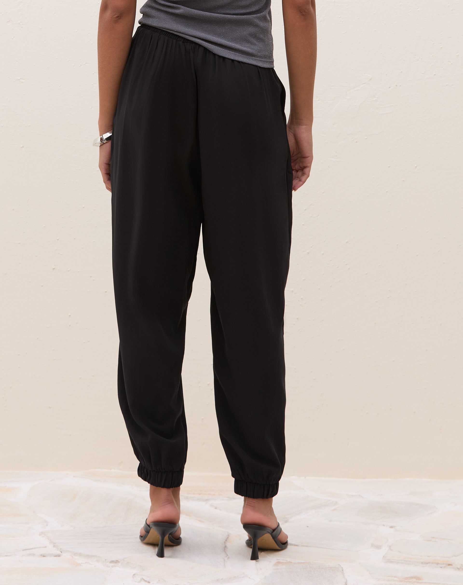 Calça Jogger Aladim preta - vista frontal alongada mostrando caimento largo e bolsos laterais discretos