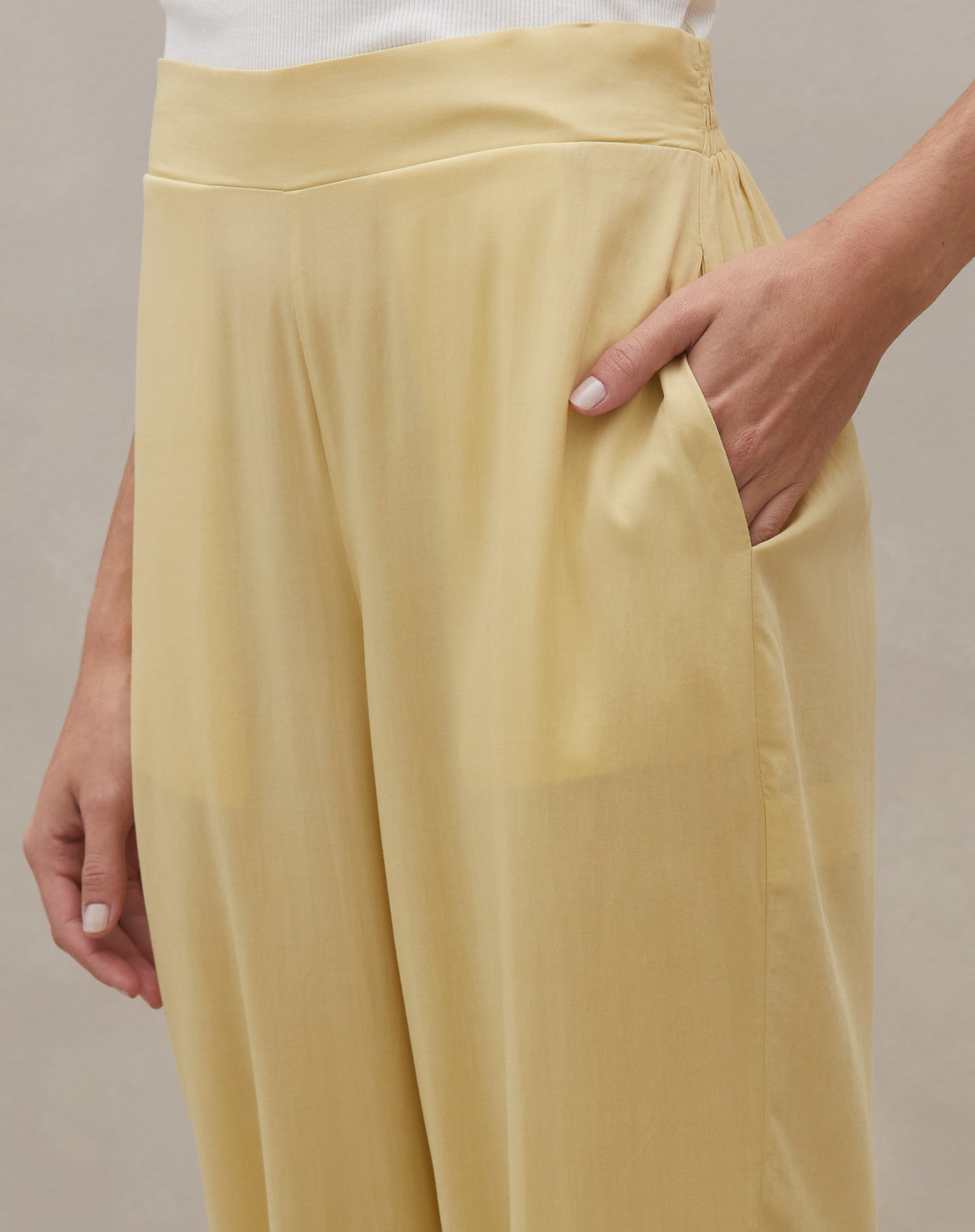 Close no cós alto e bolso lateral da Calça Jogger Aladim com a mão no bolso, destacando acabamento e tecido leve